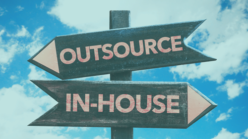 Sign post: One arrow saying outsource and another saying in-house.