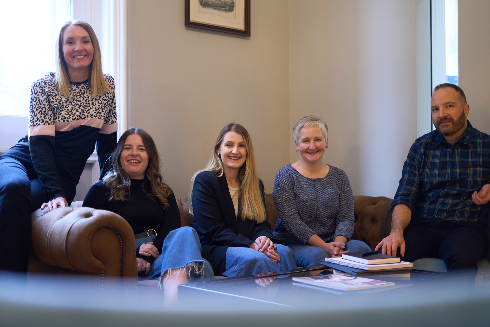 Team photo: Everyone is sitting on a brown leather sofa. Pictured left to right: Rachel Wright, Marianne Carey, Erin Cassidy, Alison O'Neill and Chris Lucarelli.