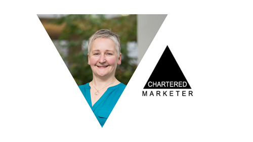 Alison O'neill smiling. She wears a blue top. Next to her is a black triangle that says chartered marketer.